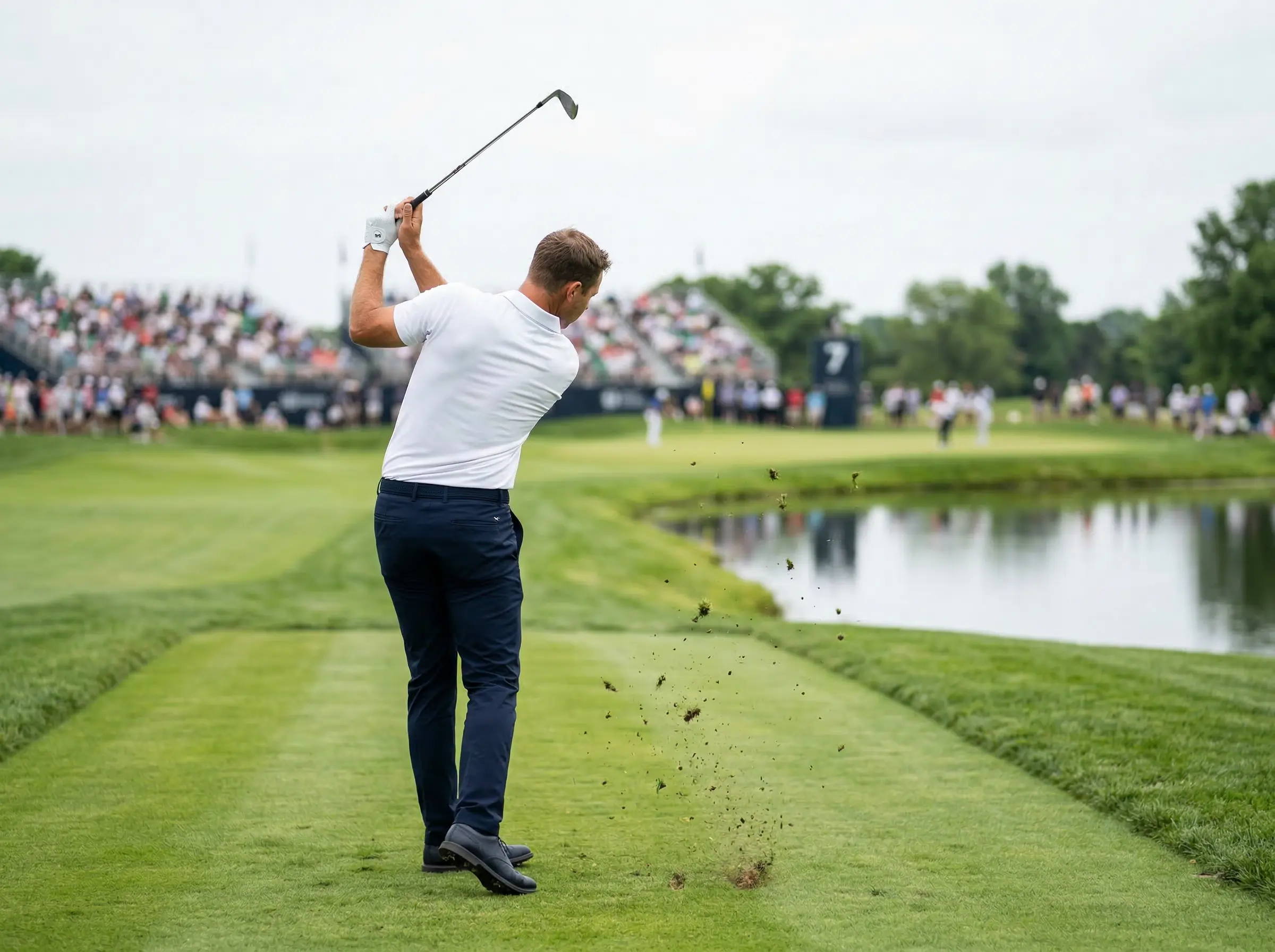 Golfista profesional ejecutando un golpe de approach en un campo de torneo major